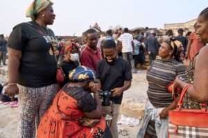 A group of traders at the Katamanto market previewing footage after an interview with Wisdom Matey Tetteh